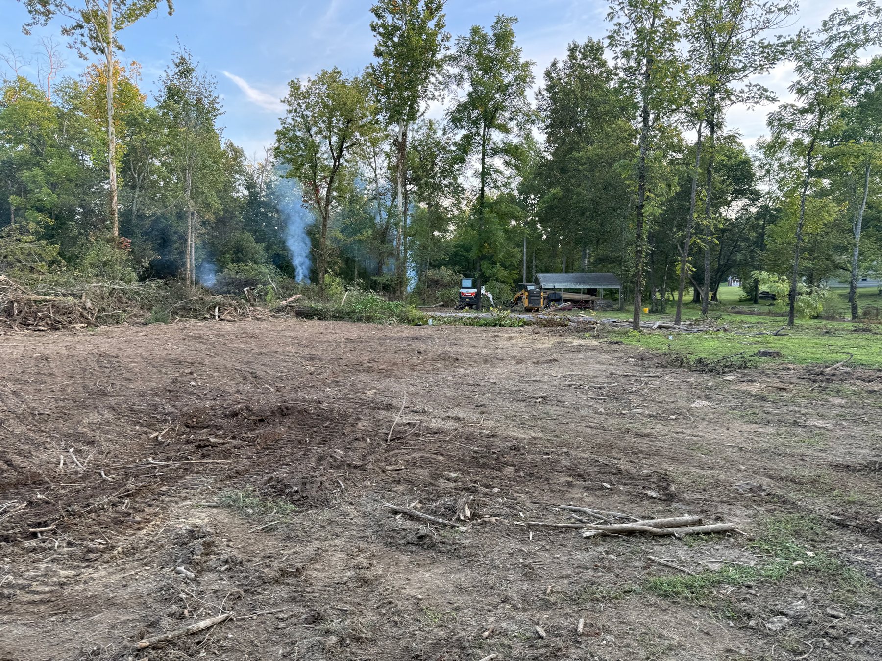 Cleared BECS land clearing job with brush piles and open ground