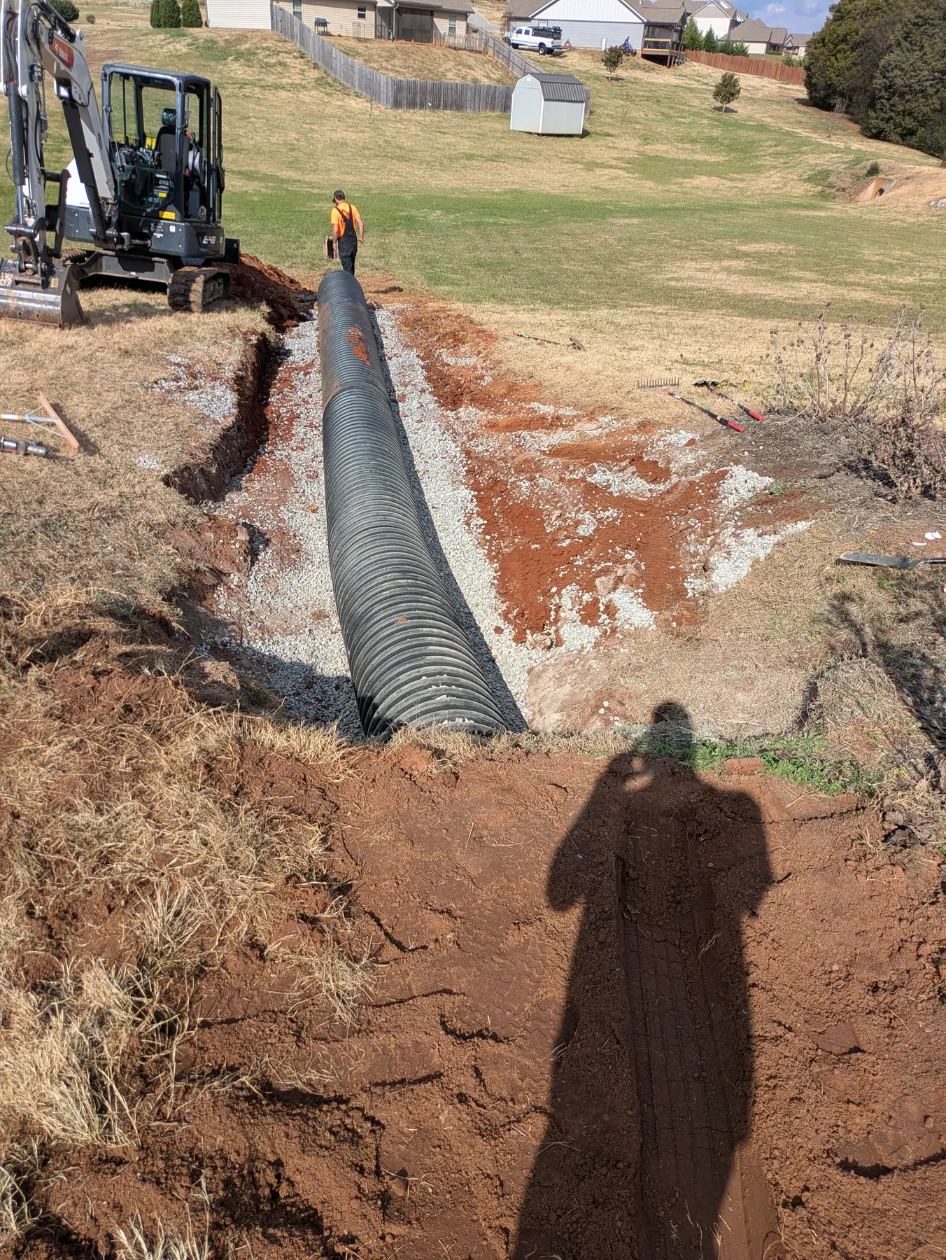 Large corrugated culvert pipe set in a stone-lined trench