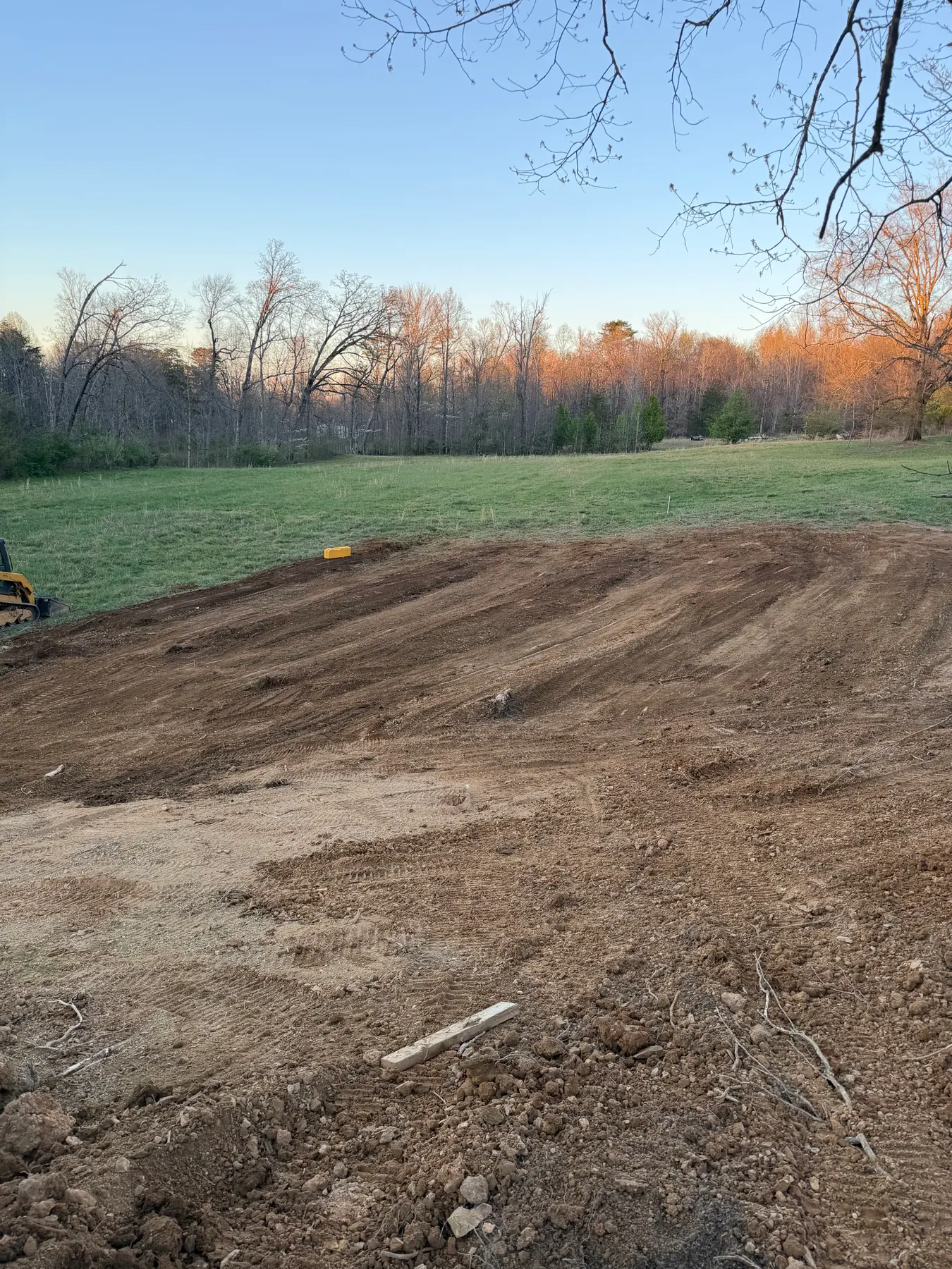 Backfilled and graded soil over a septic field installation area