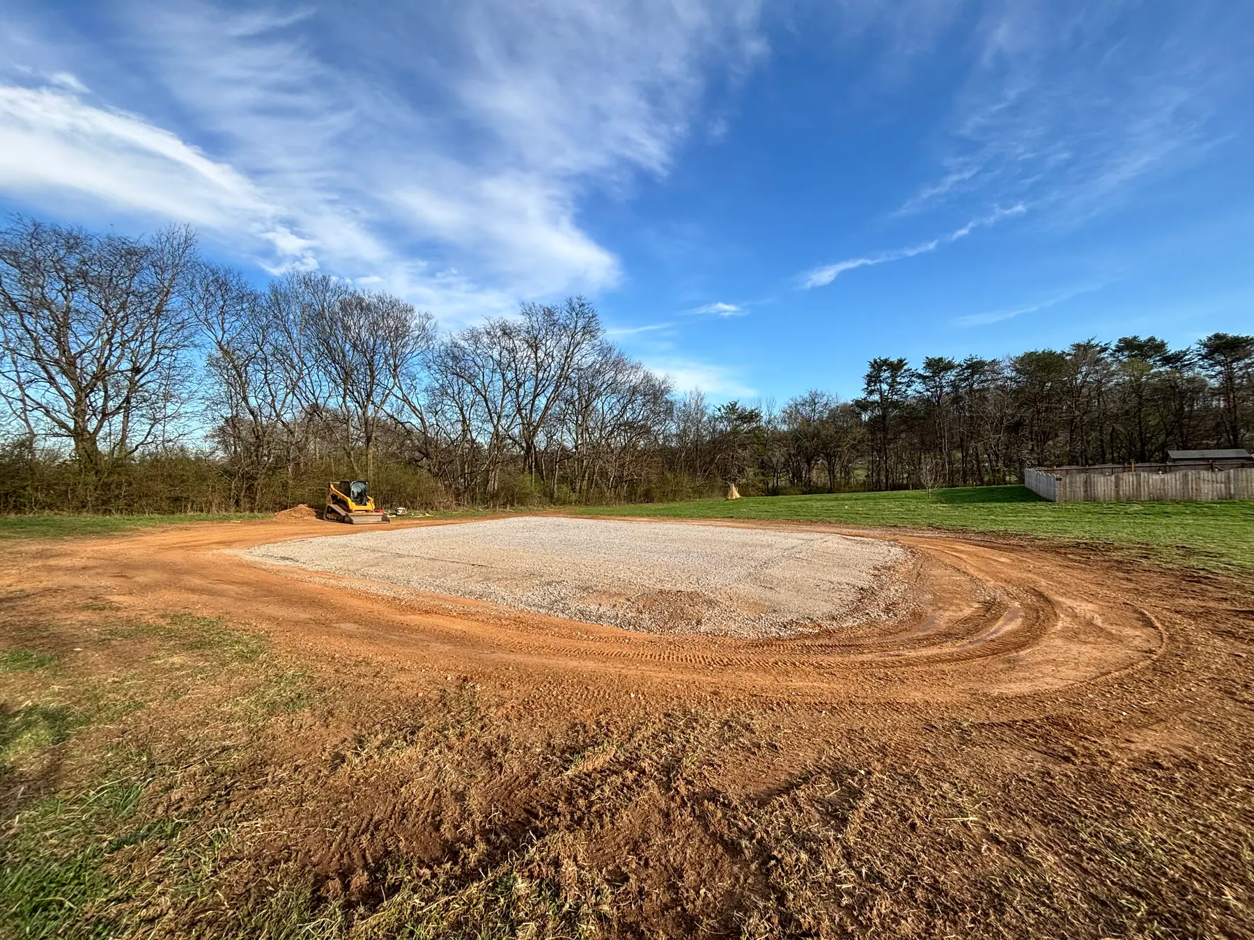 Gravel pad with surrounding ground graded on a BECS project